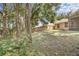 Large backyard with tall trees and a wooden fence for privacy; the house is tan with a screened porch at 1439 Bent Oaks Blvd, Deland, FL 32724