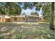 Spacious backyard featuring a screened-in porch, grass, and surrounded by lush trees and a wooden fence at 1439 Bent Oaks Blvd, Deland, FL 32724