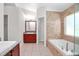 Primary bathroom featuring wood cabinets, granite countertops, soaking tub, and tiled shower at 1439 Bent Oaks Blvd, Deland, FL 32724
