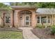 Close up of the front entry featuring a brick pathway, arched entryway, and manicured landscaping at 1439 Bent Oaks Blvd, Deland, FL 32724