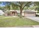 Charming single-story home with a well-manicured lawn and mature shade tree at 1439 Bent Oaks Blvd, Deland, FL 32724