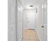 Neutral-toned hallway with a tiled floor and white doors creating a clean aesthetic at 1439 Bent Oaks Blvd, Deland, FL 32724