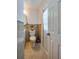 Cozy bathroom featuring tile flooring, a toilet, and a vanity, with an adjacent door at 150 Nautical Dr, South Daytona, FL 32119