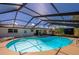 Backyard with in-ground pool featuring a screened enclosure and outdoor lounge chairs at 150 Nautical Dr, South Daytona, FL 32119