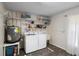 Practical laundry area includes washer, dryer, water heater, and organized shelving at 1560 S Pearl St, Deland, FL 32720