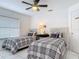 Bright bedroom features white walls, tiled floors, a ceiling fan, and two twin beds at 1578 Stone Trl, Deltona, FL 32725