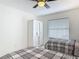 Brightly lit bedroom featuring two twin beds, closet, ceiling fan, and a large window at 1578 Stone Trl, Deltona, FL 32725