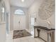 Bright foyer features a grand entrance, white tile floors, high ceilings, and an elegant console table at 1578 Stone Trl, Deltona, FL 32725