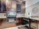 Close-up on stainless steel appliances with dark wood cabinets and granite countertops in this well-equipped kitchen at 1578 Stone Trl, Deltona, FL 32725