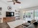 Open living area with white tile flooring, modern decor, a large TV, and access to the outdoor patio at 1578 Stone Trl, Deltona, FL 32725