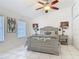 Comfortable main bedroom features white-tile floors, ceiling fan, and modern furniture at 1578 Stone Trl, Deltona, FL 32725