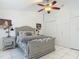 Comfortable main bedroom features white-tile floors, ceiling fan, and ample closet space at 1578 Stone Trl, Deltona, FL 32725