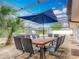 Outdoor dining area with table, seating, umbrella, and tropical landscaping by a screened pool area at 1578 Stone Trl, Deltona, FL 32725