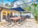Spacious outdoor dining area with a large table, seating, grill, and lush landscaping near the screened pool at 1578 Stone Trl, Deltona, FL 32725