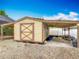 Tan outdoor shed with double doors and a covered area, providing extra storage at 1578 Stone Trl, Deltona, FL 32725