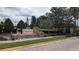 Oakhurst community entrance sign with stone accents, flag, landscaping, and brick-paved entrance drive at 1933 Oak Estates Dr, Orange City, FL 32763