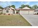 Charming single-story home featuring a three-car garage and well-maintained front yard with fresh landscaping at 1933 Oak Estates Dr, Orange City, FL 32763