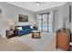 Elegant living room featuring a comfortable blue sofa, tile flooring, and sliding doors with a view of the pool at 1933 Oak Estates Dr, Orange City, FL 32763