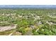 Aerial view of the home nestled within wooded acreage and near a neighboring equestrian training area at 1941 Jungle Rd, New Smyrna Beach, FL 32168