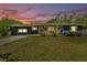 Charming home with a well-manicured front lawn at sunset at 1941 Jungle Rd, New Smyrna Beach, FL 32168
