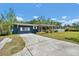 Inviting home with a driveway, grassy lawn, blue siding and a charming covered front porch at 1941 Jungle Rd, New Smyrna Beach, FL 32168