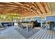 Covered patio with wood ceiling, ceiling fans, and dining set for outdoor living at 1941 Jungle Rd, New Smyrna Beach, FL 32168