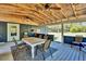 Spacious covered porch with wood ceiling, ceiling fans, and outdoor dining area at 1941 Jungle Rd, New Smyrna Beach, FL 32168
