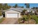 Charming single-story home with lush landscaping, mature trees, and an attached two-car garage at 219 Lynnhurst Dr, Ormond Beach, FL 32176