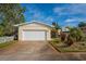 Single-story home with an attached garage, complemented by mature landscaping and a concrete driveway at 219 Lynnhurst Dr, Ormond Beach, FL 32176