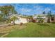 Charming home with lush landscaping, mature palms, and a well-manicured lawn at 219 Lynnhurst Dr, Ormond Beach, FL 32176