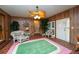 Cozy living room featuring wood paneling, a unique ceiling fan, and comfortable wicker furniture at 219 Lynnhurst Dr, Ormond Beach, FL 32176
