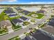 Aerial view of a community showcasing homes, a playground, and a scenic lake backdrop at 234 Mosaic Blvd, Daytona Beach, FL 32124