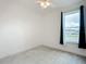 Bright, carpeted bedroom with a ceiling fan and window with neighborhood view at 234 Mosaic Blvd, Daytona Beach, FL 32124
