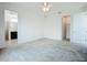 Bright, carpeted bedroom with ceiling fan, closet, and attached bathroom entrance at 234 Mosaic Blvd, Daytona Beach, FL 32124