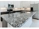Close up of the kitchen island, with beautiful black-veined granite countertops and modern finishes at 234 Mosaic Blvd, Daytona Beach, FL 32124