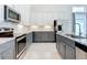 Modern kitchen with stainless steel appliances, sleek two-tone cabinetry, and granite countertops at 234 Mosaic Blvd, Daytona Beach, FL 32124