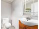 Bathroom with a classic vanity, toilet, and an ornate mirror reflecting natural light at 2524 Anastasia Dr, South Daytona, FL 32119