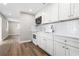 Bright kitchen featuring white cabinets, countertops and backsplash, with wood-look floors at 2524 Anastasia Dr, South Daytona, FL 32119