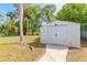 Backyard shed surrounded by lush greenery and shady trees, perfect for storage or hobbies at 2605 Fairmont Ave, New Smyrna Beach, FL 32168
