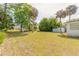 Expansive backyard with lush green grass, mature trees, and a shed, providing ample space at 2605 Fairmont Ave, New Smyrna Beach, FL 32168