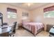 Comfortable bedroom with a full-sized bed, desk, and a view of the outside at 2605 Fairmont Ave, New Smyrna Beach, FL 32168