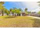 Inviting single-story home featuring lush green lawn, mature trees, and convenient covered parking at 2605 Fairmont Ave, New Smyrna Beach, FL 32168