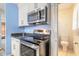 Close up of kitchen featuring stainless steel stove and microwave with white cabinetry, with a view of a water closet at 2605 Fairmont Ave, New Smyrna Beach, FL 32168