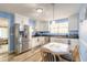 Cozy kitchen featuring white cabinets, stainless steel appliances, and a charming breakfast nook with blue accents at 2605 Fairmont Ave, New Smyrna Beach, FL 32168