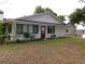 Backyard with a white exterior and a small, well-kept lawn at 26225 Troon Ave, Mount Plymouth, FL 32776