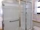 Bathroom features a walk-in shower with glass doors, a grab bar, and neutral-toned tile at 26225 Troon Ave, Mount Plymouth, FL 32776