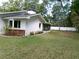 Exterior of home with white siding, a screened-in porch, and a well-maintained lawn at 26225 Troon Ave, Mount Plymouth, FL 32776