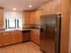 Bright kitchen featuring stainless steel appliances, wood cabinets, and a window over the sink at 26225 Troon Ave, Mount Plymouth, FL 32776