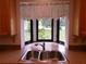 A kitchen sink with a view of a garden through a bright window and a pink flower in the garden at 26225 Troon Ave, Mount Plymouth, FL 32776