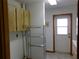 Laundry room features a door to the exterior, upper cabinets, and shelving for supplies at 26225 Troon Ave, Mount Plymouth, FL 32776